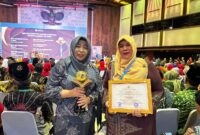 Kadisdikbud Kota Langsa Dra.Suhartini M.Pd (kiri) menerima trofi penghargaan dari Kementerian Lingkungan Hidup dan Kehutanan Republik Indonesia 
