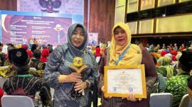 Kadisdikbud Kota Langsa Dra.Suhartini M.Pd (kiri) menerima trofi penghargaan dari Kementerian Lingkungan Hidup dan Kehutanan Republik Indonesia 