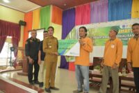 Pj Walikota Langsa Syaridin secara simbolis memberikan kartu BPJS Ketenagakerjaan kepada salah satu pemilik kebun sawit.