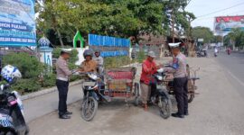 Kepala Urusan Pembinaan Operasi (KBO) Lantas Polres Aceh Utara Ipda Irvan, membagikan nasi kotak kepada tukang becak, pedagang kaki lima.