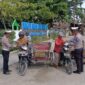 Kepala Urusan Pembinaan Operasi (KBO) Lantas Polres Aceh Utara Ipda Irvan, membagikan nasi kotak kepada tukang becak, pedagang kaki lima.