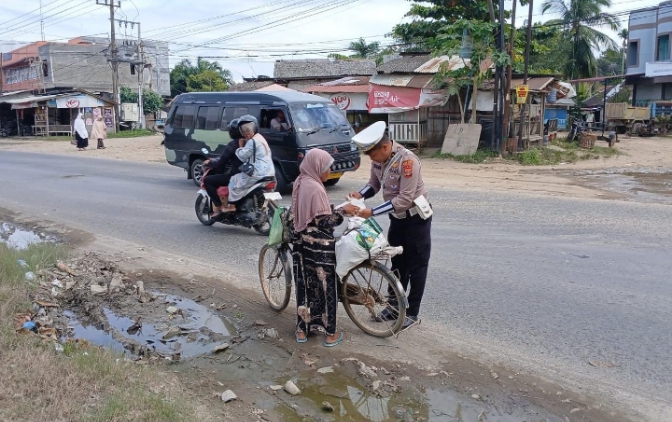 Ipda Irvan saat memberikan nasi kotak kepada warga 