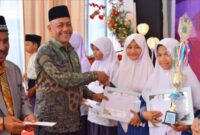 Kakankemenag Aceh Utara memberikan sertifikat dan hadiah kepada siswi berprestasi