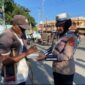 Salah seorang Polwan Satlantas Polres Lhokseumawe memberikan nasi kotak kepada warga yang membutuhkan 