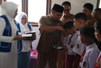Pj Bupati Aceh Besar Muhammad Iswanto, S.STP, MM membagikan Makanan Bergizi Gratis (MBG) di SDN Mon Singet, Gampong Kajhu, Kecamatan Baitussalam, Aceh Besar, Senin (10/02/2025).