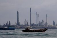 Dokumentasi Foto CNBC : Kapal berlayar melewati kilang minyak Pulau Bukom di sepanjang pantai selatan Singapura