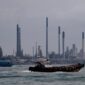 Dokumentasi Foto CNBC : Kapal berlayar melewati kilang minyak Pulau Bukom di sepanjang pantai selatan Singapura