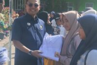 Walikota Langsa Jeffry Sentana S Putra SE saat memberikan seragam sekolah kepada salah seorang Siswi SMP Negeri I Langsa 