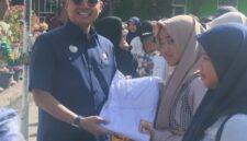 Walikota Langsa Jeffry Sentana S Putra SE saat memberikan seragam sekolah kepada salah seorang Siswi SMP Negeri I Langsa 