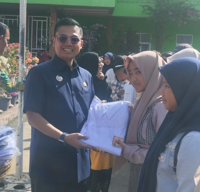 Walikota Langsa Jeffry Sentana S Putra SE saat memberikan seragam sekolah kepada salah seorang Siswi SMP Negeri I Langsa 