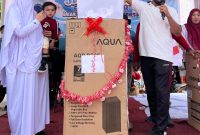 Pj Geuchik Gampong Karang Anyar, Hartama SSTP, saat menyerahkan hadiah utama kepada warga berupa satu unit lemari es, usai mengikuti jalan sehat, di lapangan setempat, Minggu, 24 Agustus 2025.