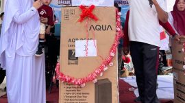 Pj Geuchik Gampong Karang Anyar, Hartama SSTP, saat menyerahkan hadiah utama kepada warga berupa satu unit lemari es, usai mengikuti jalan sehat, di lapangan setempat, Minggu, 24 Agustus 2025.