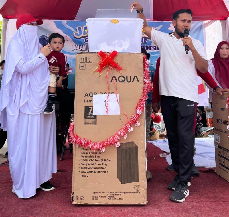 Pj Geuchik Gampong Karang Anyar, Hartama SSTP, saat menyerahkan hadiah utama kepada warga berupa satu unit lemari es, usai mengikuti jalan sehat, di lapangan setempat, Minggu, 24 Agustus 2025.