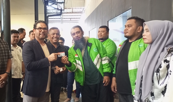 Pembina IMI Aceh dan Anggota Komisi III DPR RI Fraksi PKS Dr.H.M.Nasir Djamil M.Si yang didampingi Ketua IMI Langsa Dalem Syukri ST secara simbolis menyerahkan SIM gratis kepada salah seorang driver Ojol di Station Cafe Langsa