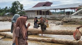 warga gampong jambak, Pante Cermin mencai sisa barang rumah yang tersisa di bawah runtuhan bangunan. Jumat 28/11/2025.