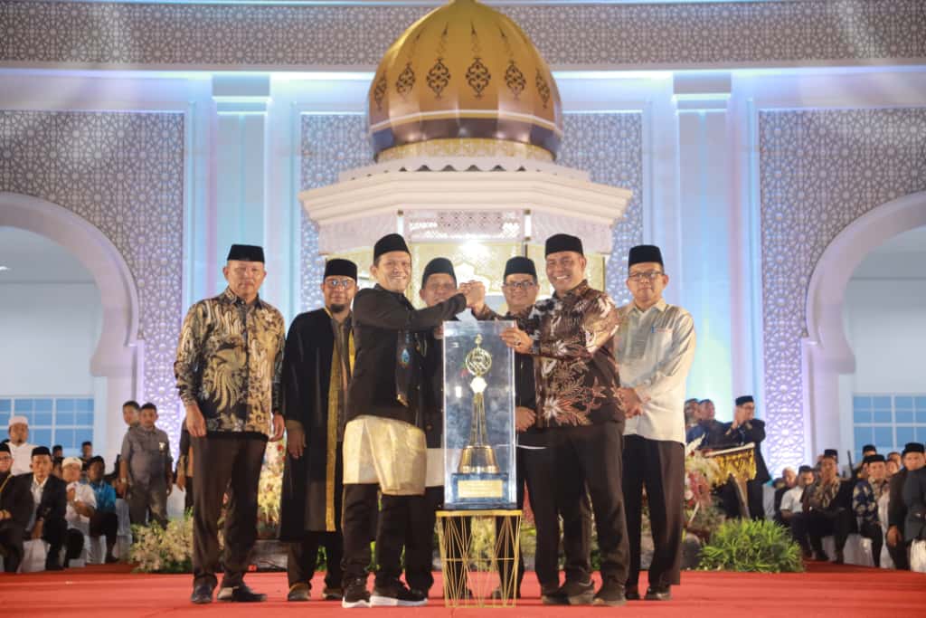 Bupati Aceh Besar H Muharram Idris (Syech Muharram) menerima piala bergilir juara umum MTQ ke-37 Aceh tahun 2025, dari Wakil Gubernur Aceh Fadhlullah SE, pada malam penutupan, di Arena Utama, Komplek Perkantoran Pemkab Pidie Jaya, Jumat (7/11/2025) malam.