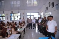 Bupati Aceh Besar H Muharram Idris didampingi Asisten 1 Farhan AP, Plt Kadisdikbud Aceh Besar Dr Agus Jumaidi SPd MPd, Kadisdik Dayah Aceh Besar Abu Bakar SAg, dan Muspika Peukan Bada meninjau pelaksanaan program ujian Beut Kitab Bak Sikula di SMPN 1 Peukan Bada, Jumat (05/12/2025).