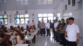 Bupati Aceh Besar H Muharram Idris didampingi Asisten 1 Farhan AP, Plt Kadisdikbud Aceh Besar Dr Agus Jumaidi SPd MPd, Kadisdik Dayah Aceh Besar Abu Bakar SAg, dan Muspika Peukan Bada meninjau pelaksanaan program ujian Beut Kitab Bak Sikula di SMPN 1 Peukan Bada, Jumat (05/12/2025).