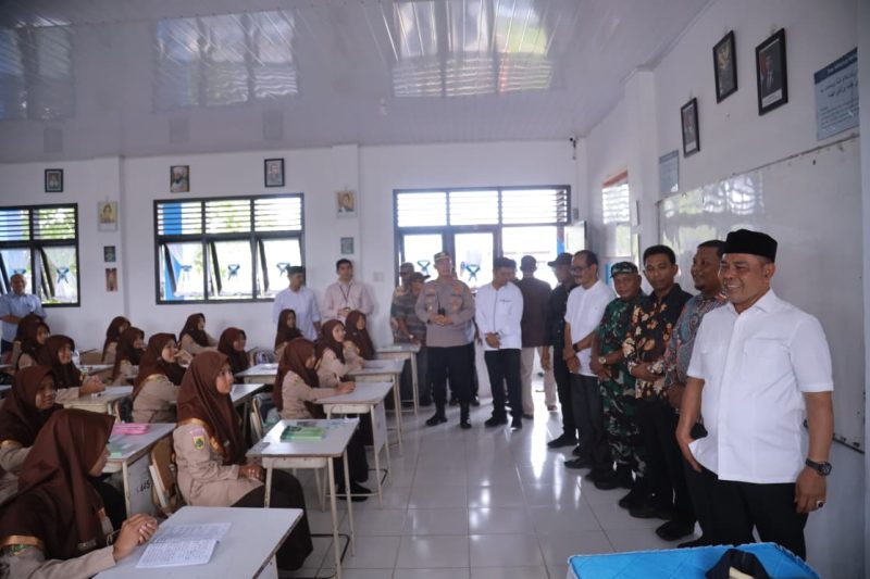 Bupati Aceh Besar H Muharram Idris didampingi Asisten 1 Farhan AP, Plt Kadisdikbud Aceh Besar Dr Agus Jumaidi SPd MPd, Kadisdik Dayah Aceh Besar Abu Bakar SAg, dan Muspika Peukan Bada meninjau pelaksanaan program ujian Beut Kitab Bak Sikula di SMPN 1 Peukan Bada, Jumat (05/12/2025).