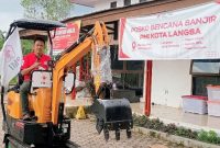 Bendahara Palang Merah Indonesia Kota Langsa Ngatiman S.Pd saat mencoba excavator mini