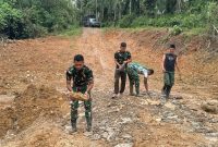 personel Satgas TMMD telah menyatu dengan warga dengan mengunakan cakul, parang, dan sekop bersihkan badan jalan selama ini menjadi akses utama masyarakat