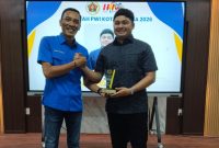 Ketua PWI Kota Langsa Putra Zulfirman saat memberikan penghargaan kepada Anggota DPR Aceh Raja Lukman Ziaulhaq pada peringatan hari Pers Nasional dan HUT PWI ke 80 di Aula IAIN langsa