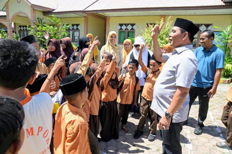 Bupati Aceh Besar, H Muharram Idris tampak penuh keakrab dengan murid saat berkunjung di SDN Limpok, Darussalam, Aceh Besar, Jumat (08/05/2026). 